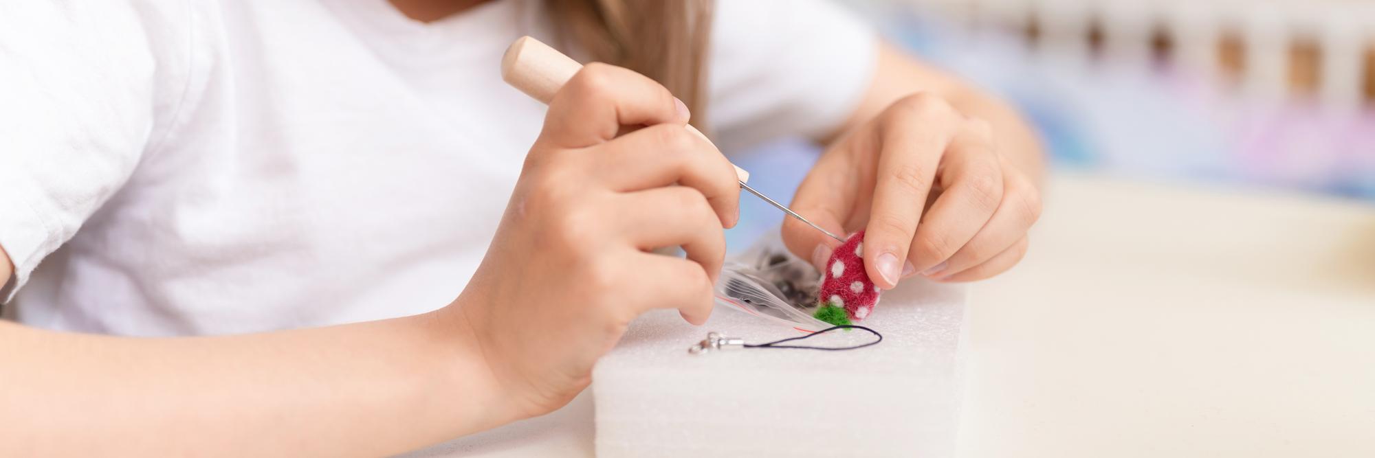 Teacher demonstrating embroidery stitch to student